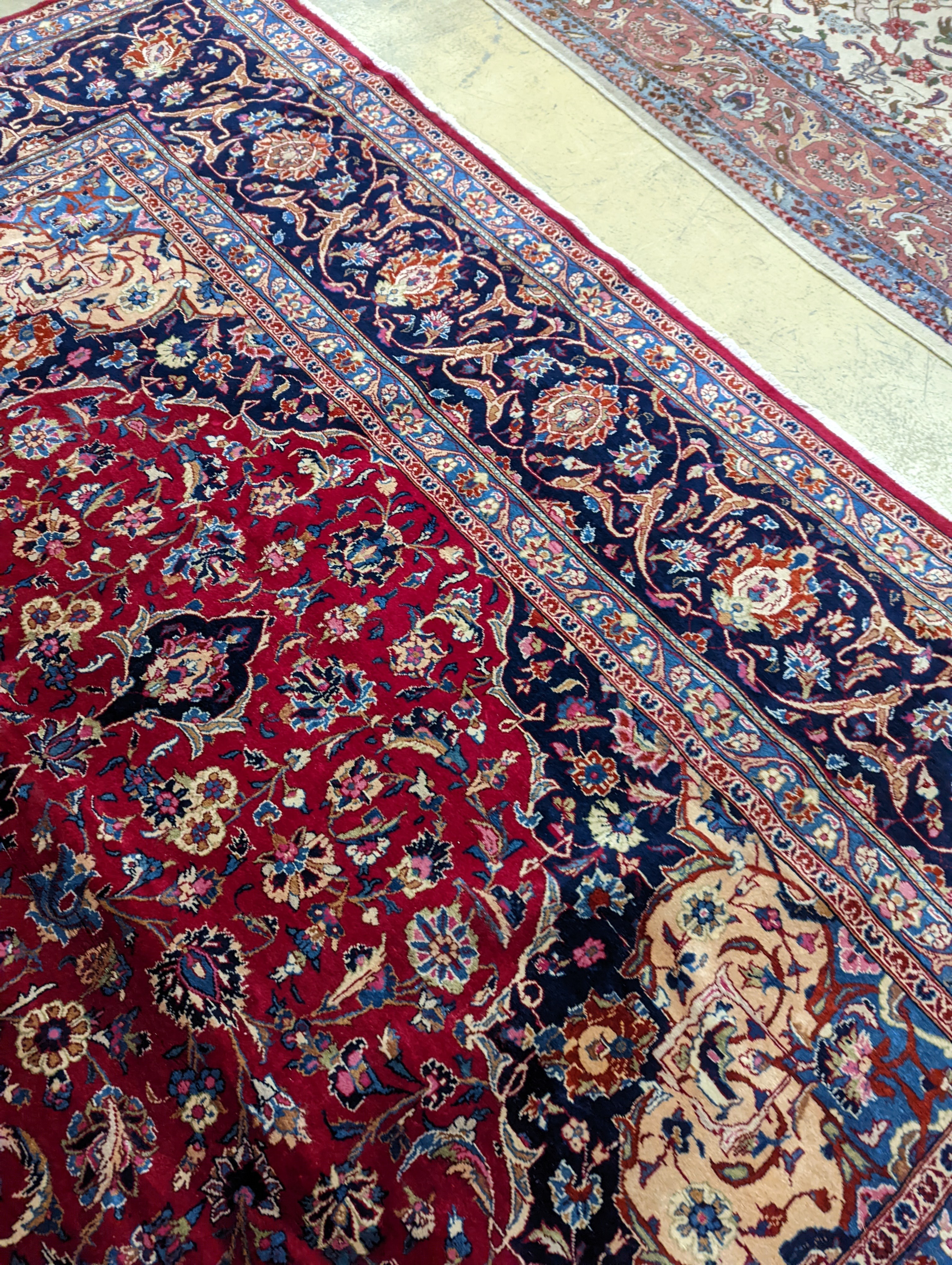 A Kashan burgundy ground carpet, 380 x 300cm